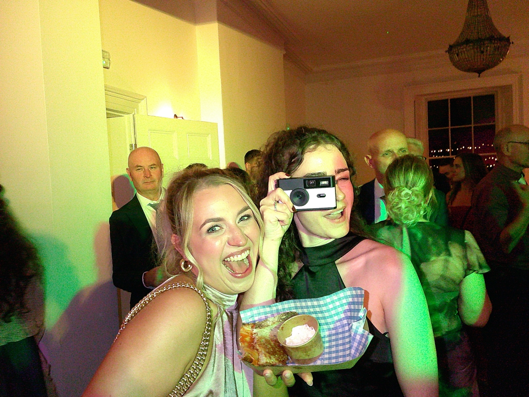 Wedding guests laughing while holding a SnapBox camera